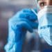 Profissional de saúde com máscara e luvas representa os médicos formados no exterior que aguardam o resultado da primeira etapa do Revalida 2026/1