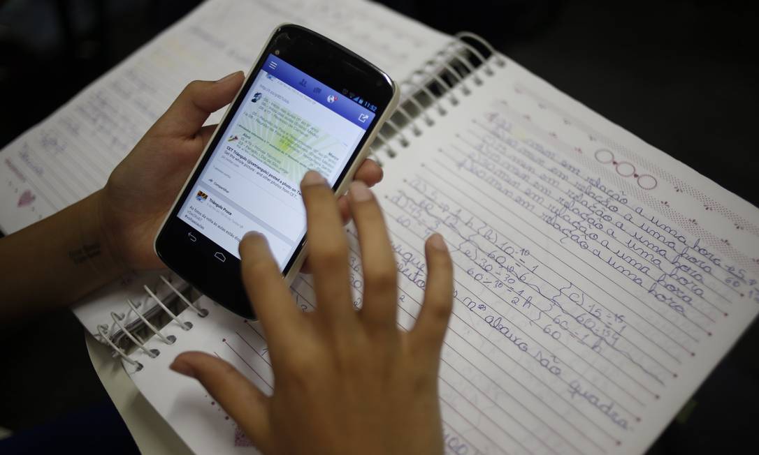 Aluno a estudar pelo celular. Imagem: Paula Giolito / Agência O Globo