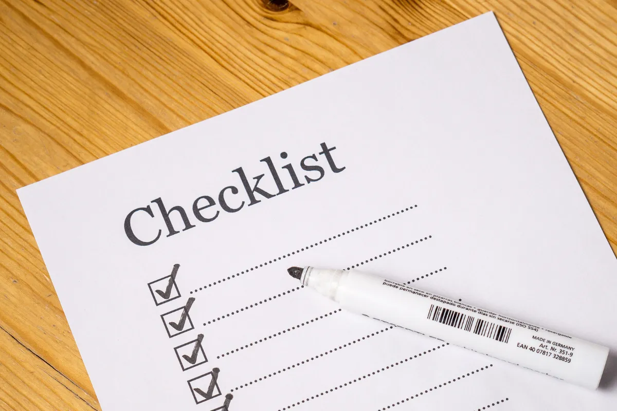 Checklist preenchido com caneta sobre mesa de madeira