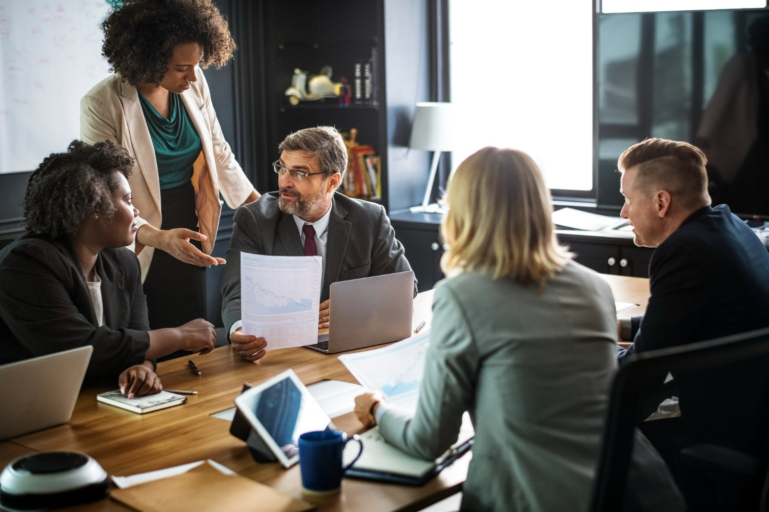 Profissionais de recursos humanos discutindo gráficos e estratégias em uma reunião de trabalho, representando o crescimento da área.