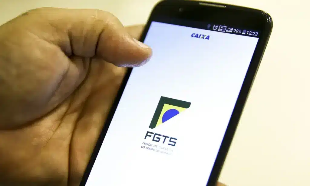 Pessoa acessando o aplicativo FGTS no celular para solicitar o Saque Calamidade do FGTS