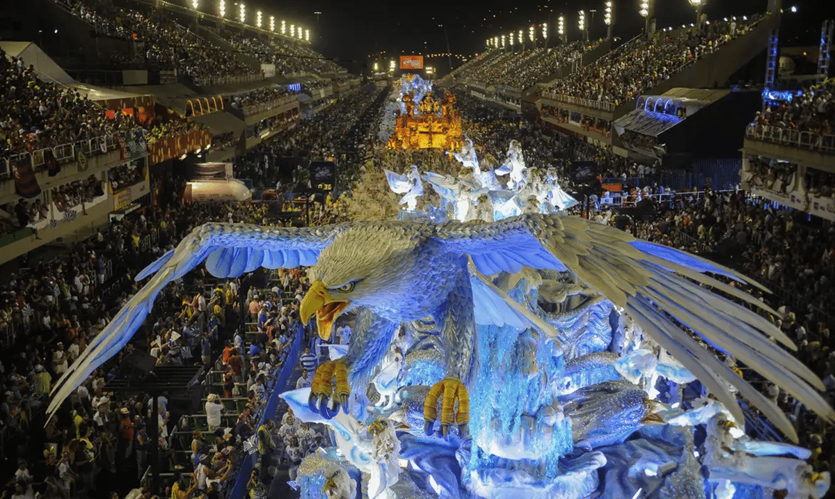 Desfile de carnaval com carro alegórico, representando a grande festa que acontecerá em março de 2025.