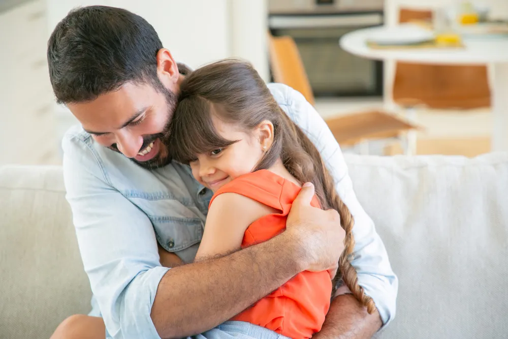 Pai abraçando a filha com carinho, demonstrando afeto e conexão emocional.