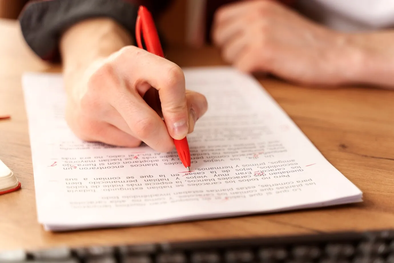  Pessoa revisando um documento com marcações em vermelho.