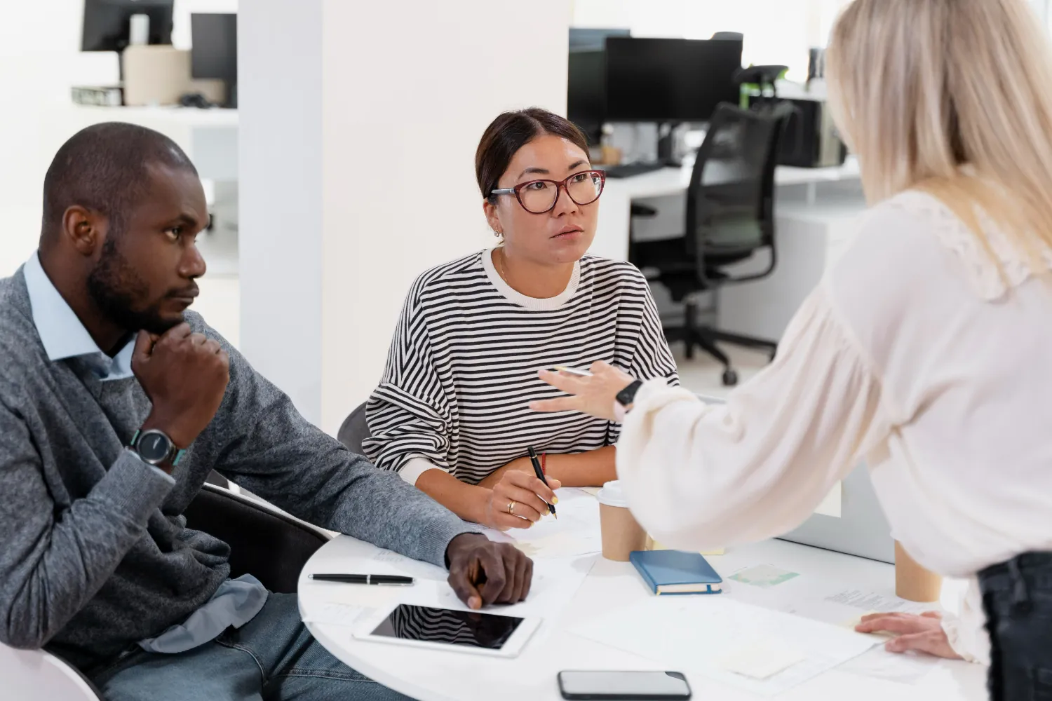 Pessoa com expressão de desconforto durante uma discussão de grupo, simbolizando dificuldade em expressar opiniões.