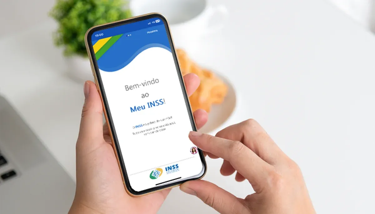 Pessoa utilizando o aplicativo Meu INSS no celular, acessando a plataforma para realizar a prova de vida