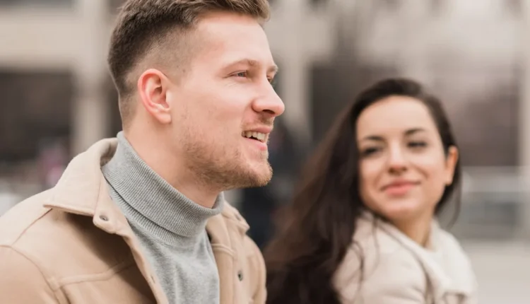 Casal sentado ao ar livre, com uma expressão de atração e admiração um pelo outro