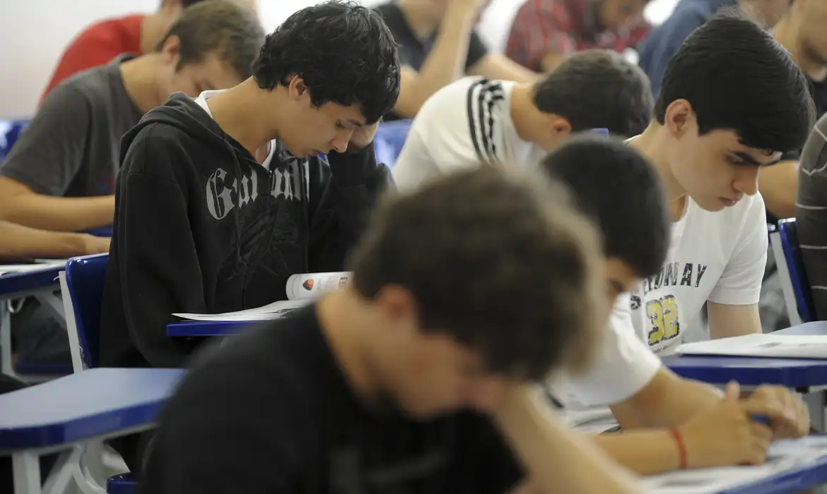 Estudantes realizando provas de seleção em sala de aula.