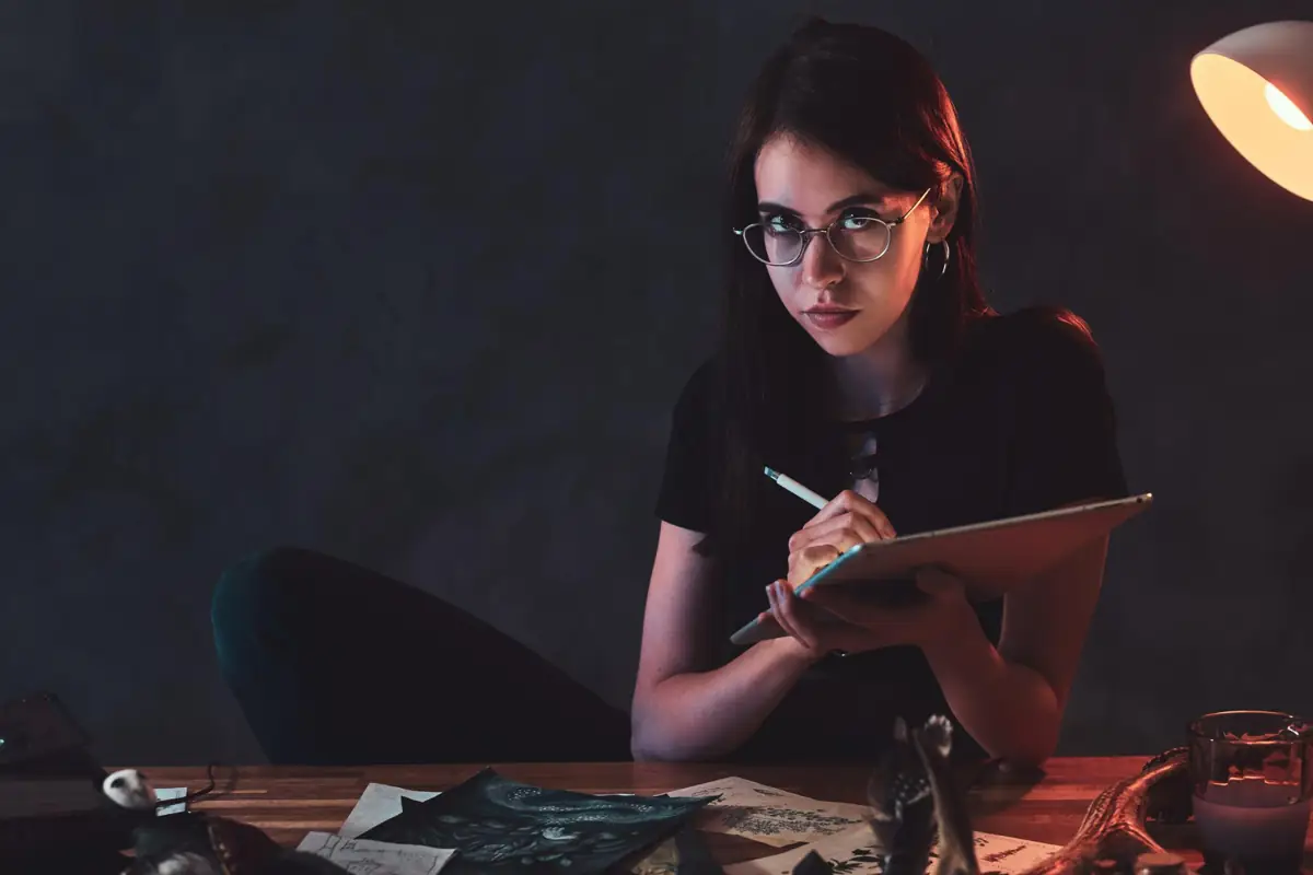 Mulher concentrada estudando e desenhando enquanto investe em sua educação e capacitação.
