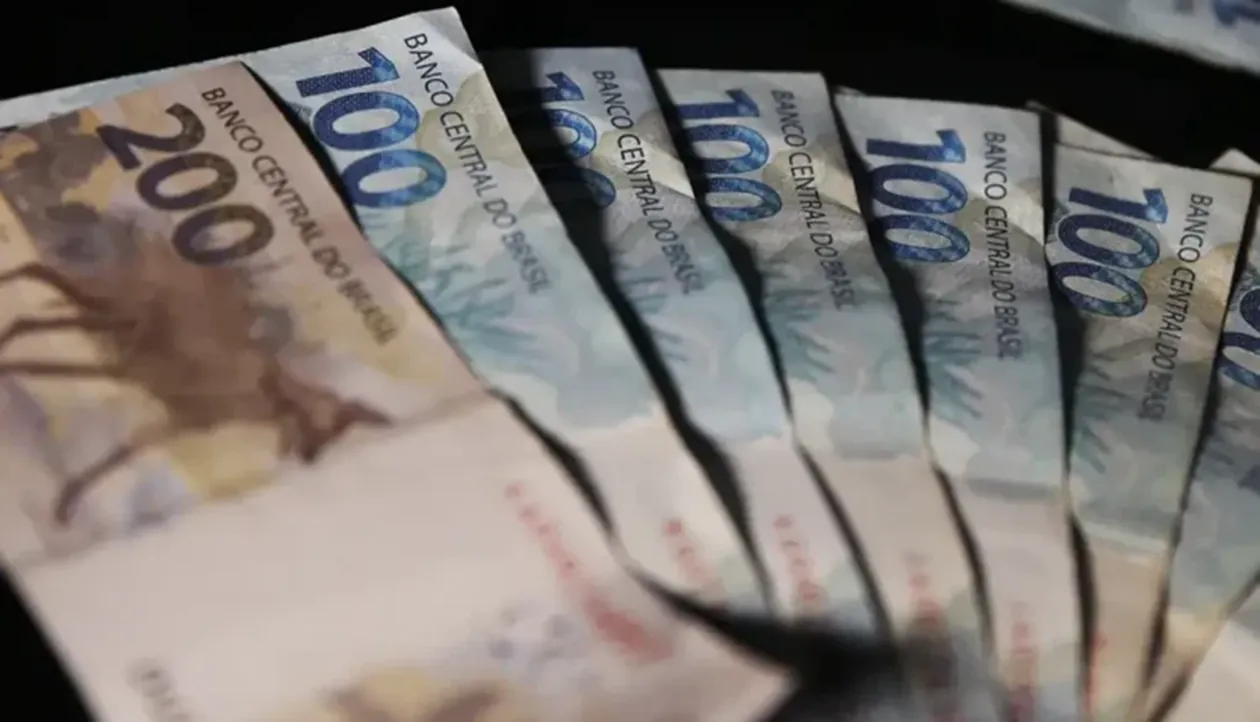 Cédulas de 100 e 200 reais emitidas pelo Banco Central do Brasil dispostas em leque.