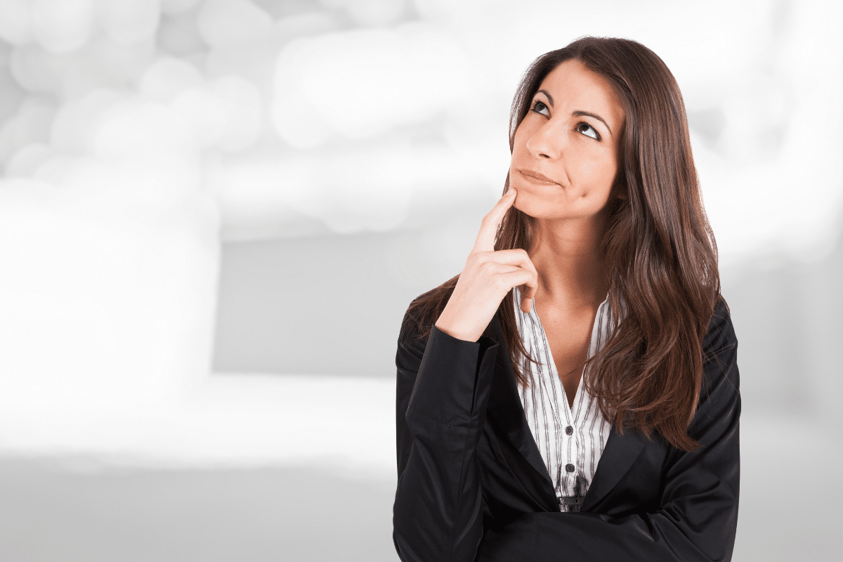 Mulher com roupa formal, pensativa, refletindo sobre uma decisão importante.