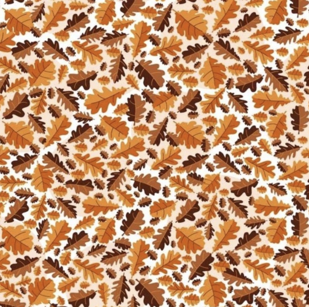 Imagem com várias folhas de carvalho em tons outonais, onde uma noz está camuflada entre elas como parte de um teste visual.