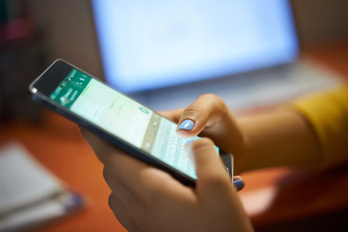 Pessoa digitando mensagem no WhatsApp em um smartphone.