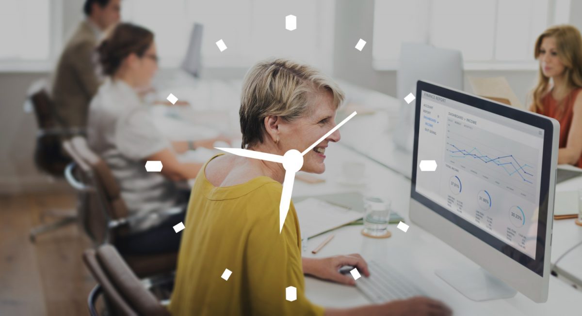 Mulher sorridente trabalhando no computador em escritório moderno, com um relógio sobreposto na imagem.