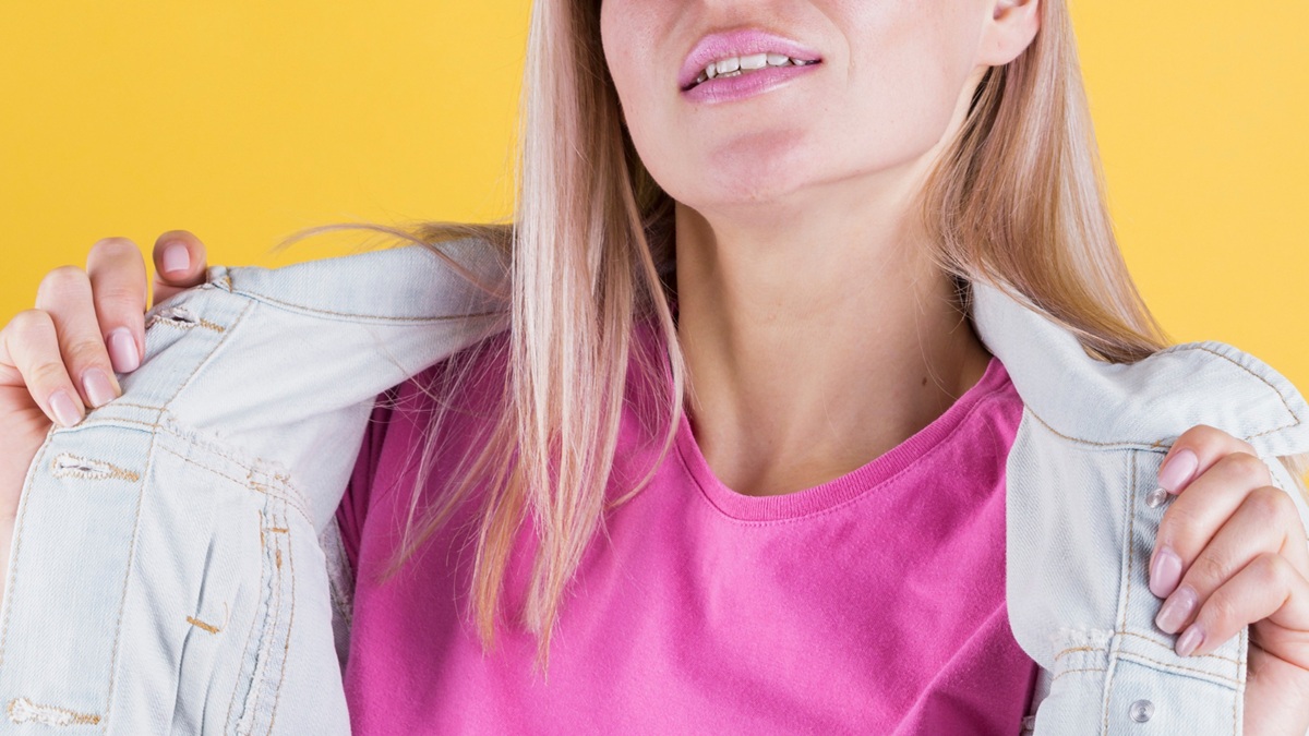 Jovem loira com jaqueta aberta, mostrando um blusa rosa