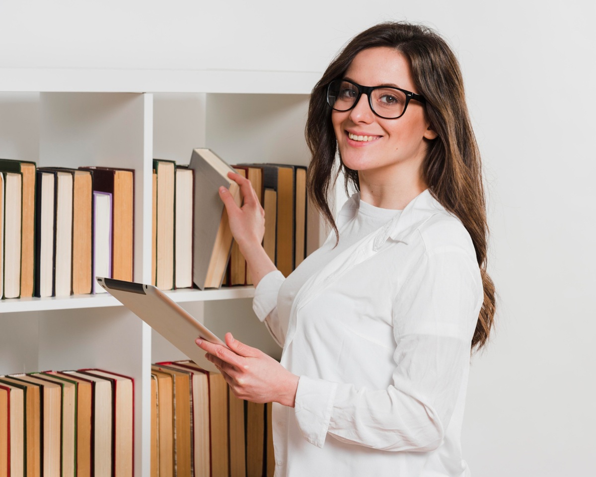 Profissional consultando livros em uma biblioteca, representando a análise ética aplicada nas organizações.