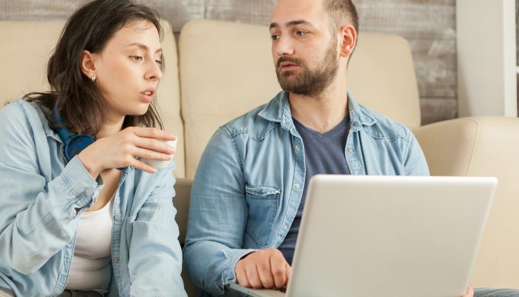 Homem e mulher olhando um para o outro com expressão séria em um ambiente interno