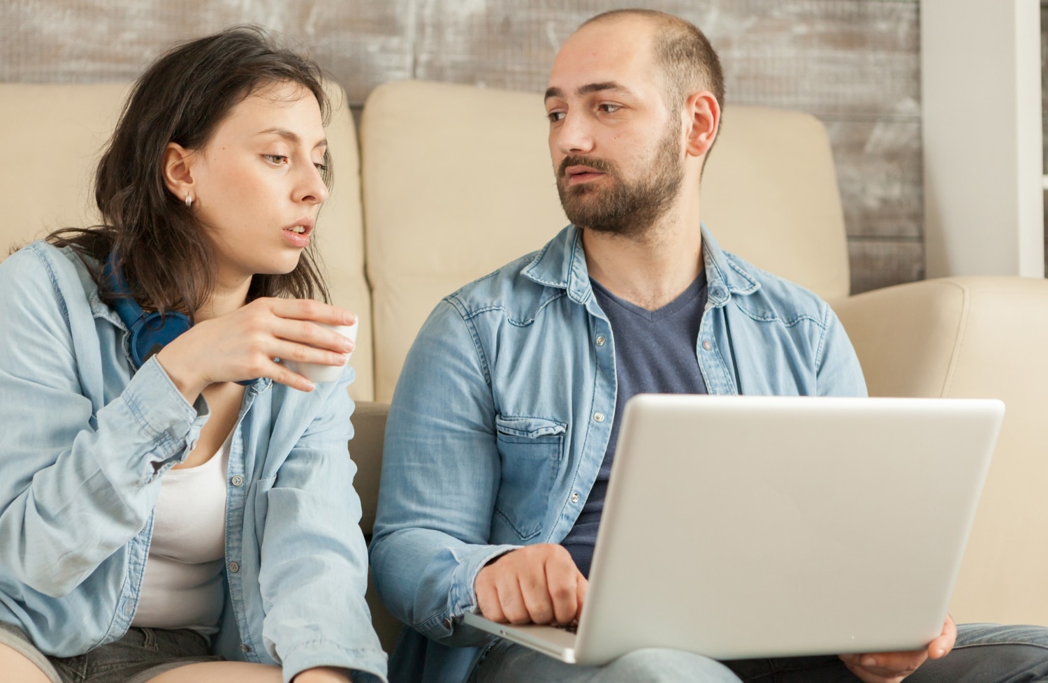 Homem e mulher olhando um para o outro com expressão séria em um ambiente interno