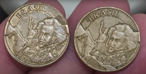 Duas moedas brasileiras de 10 centavos com defeitos visíveis de fabricação, seguradas por uma mão.