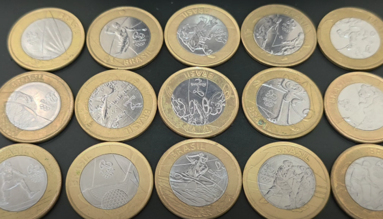 Diversas moedas comemorativas das Olimpíadas brasileiras exibidas em fundo preto.