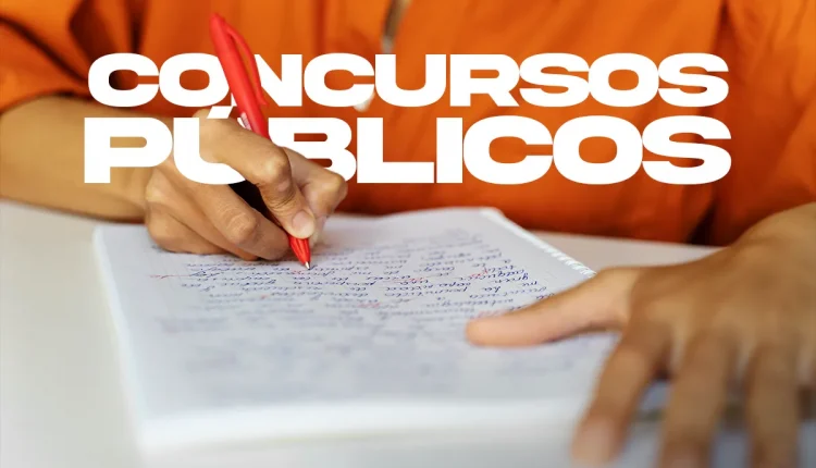 Pessoa com camisa laranja escrevendo à mão em caderno, representando estudos para concurso público.