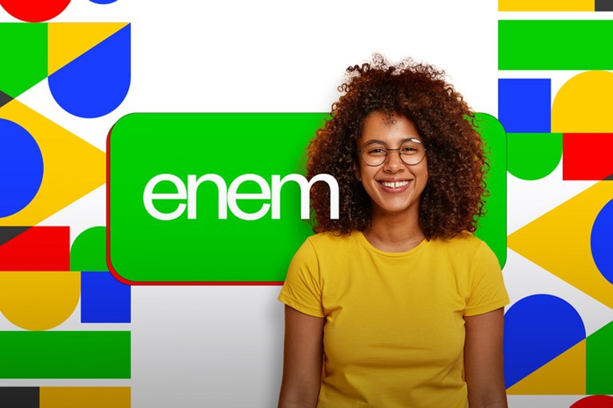 Jovem sorridente com cabelo cacheado e óculos em fundo colorido com logo do Enem.