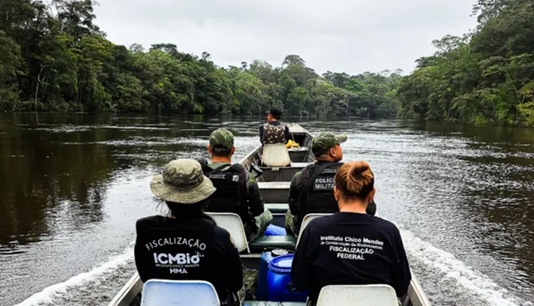 Equipe do ICMBio e Polícia Militar em ação na Amazônia, fiscalizando áreas protegidas em uma embarcação.