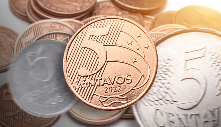 moeda de 5 centavos do brasil destacada sobre outras moedas em fundo desfocado