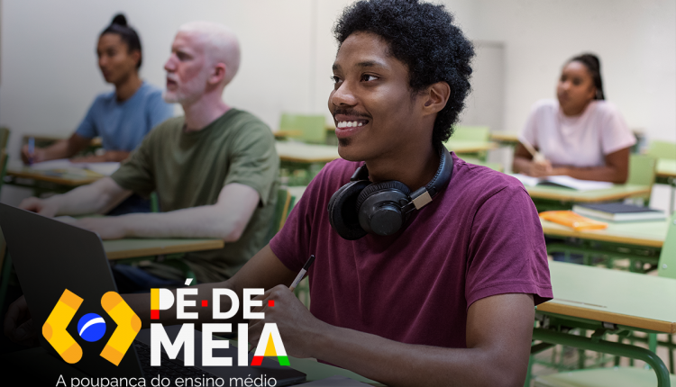 Jovem sentado em sala de aula com laptop, com o logo do programa Pé-de-Meia.