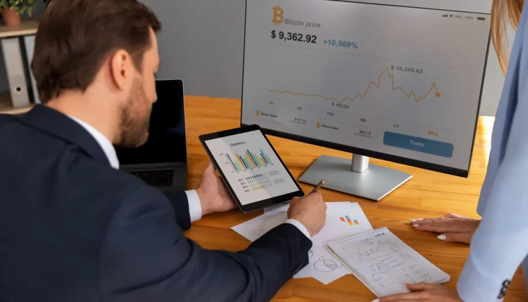 Profissional analisando gráficos financeiros e o preço do Bitcoin em uma tela de computador.