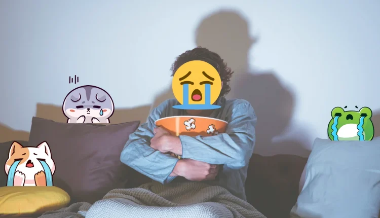 Pessoa assistindo filme, segurando pote de pipoca e rodeada de emojis chorando, representando emoções despertadas por filmes.