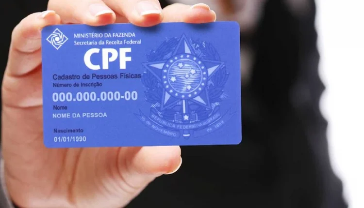 Cartão CPF azul sendo segurado por uma mão, com dados de cadastro fictícios.