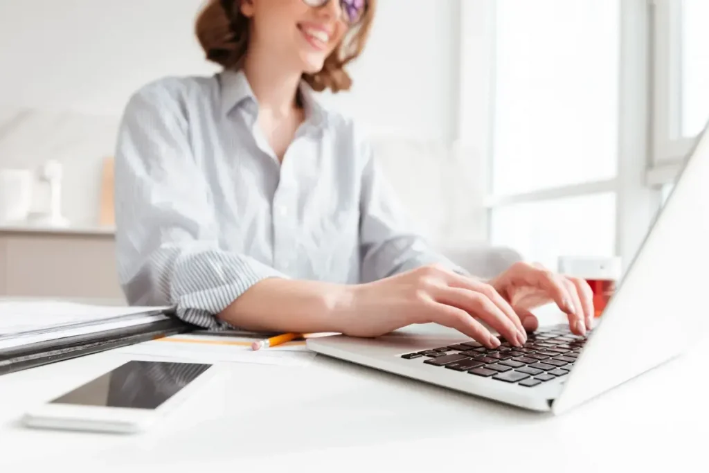  Mulher digitando em laptop, preparando denúncia ao INSS
