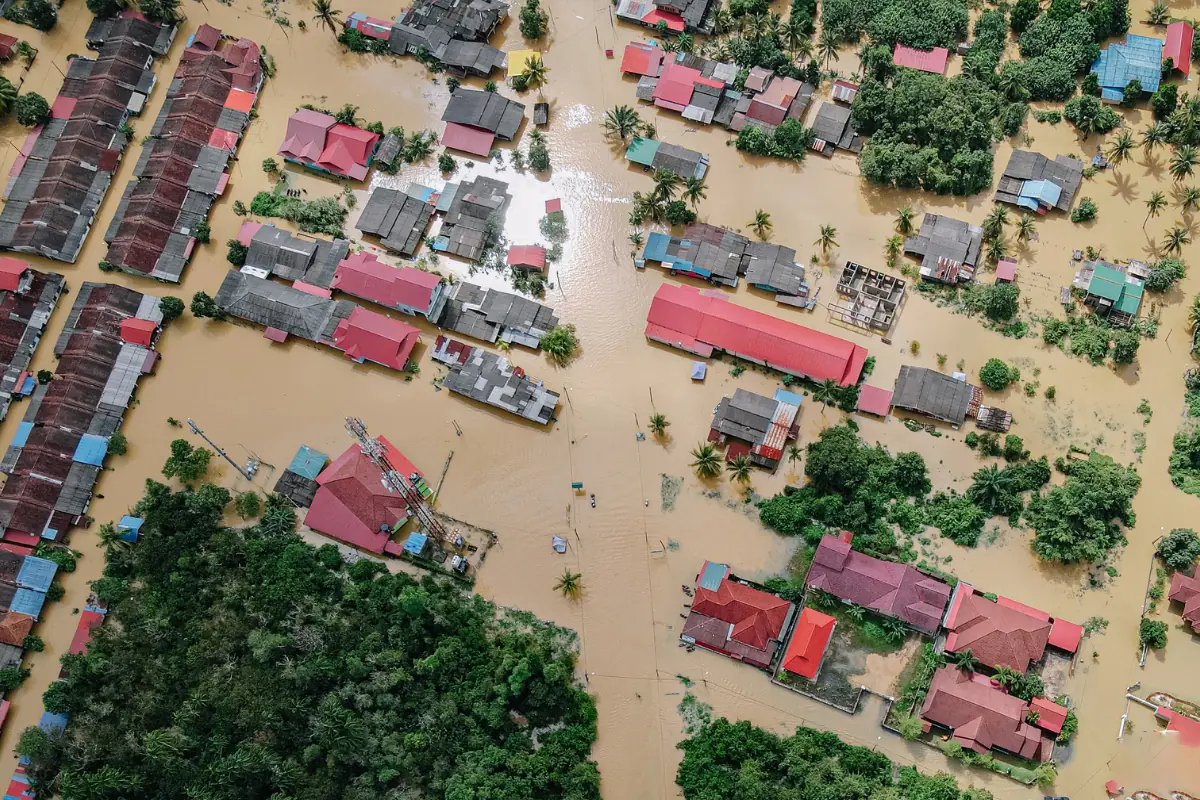 Vista aérea de área residencial alagada após enchente.