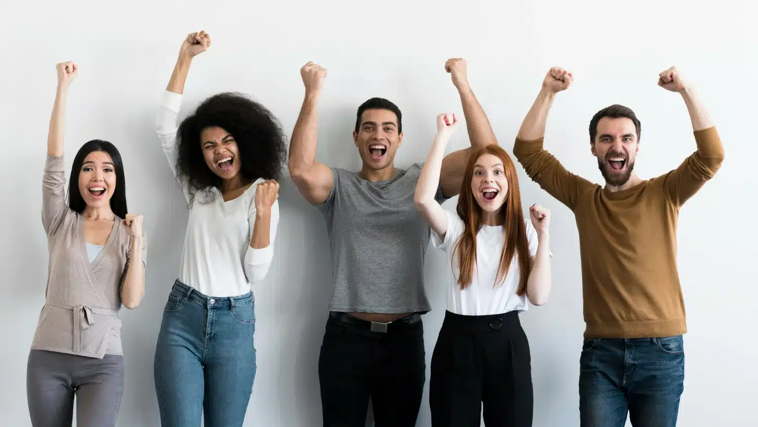 Pessoas diversas comemorando juntas com expressão de alegria e vitória.