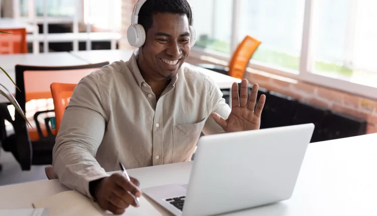 Homem sorrindo durante aula online com fones de ouvido