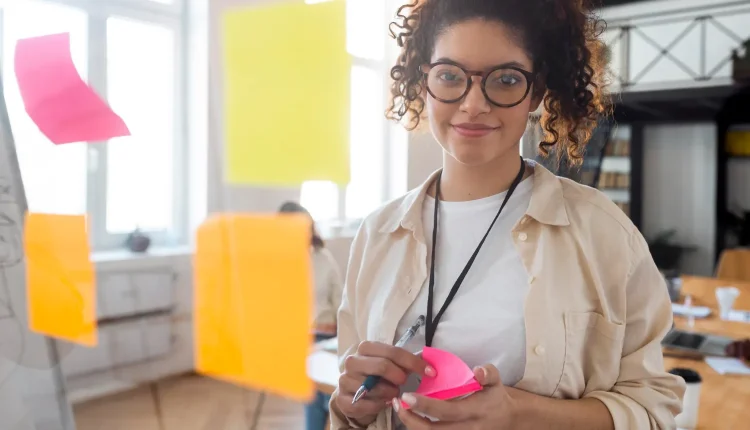Pessoa segurando post-its durante uma dinâmica de brainstorming no trabalho
