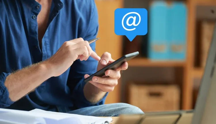 Homem usando smartphone para enviar e-mails ou mensagens eletrônicas.
