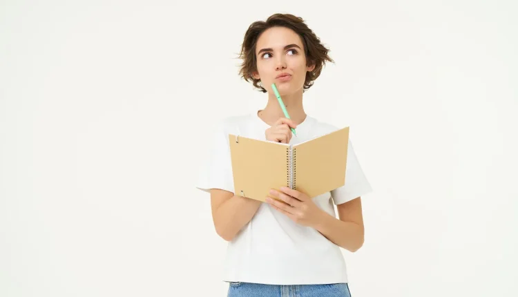 Pessoa com caderno na mão, refletindo sobre o uso correto do acento em 'início' e 'inicio'