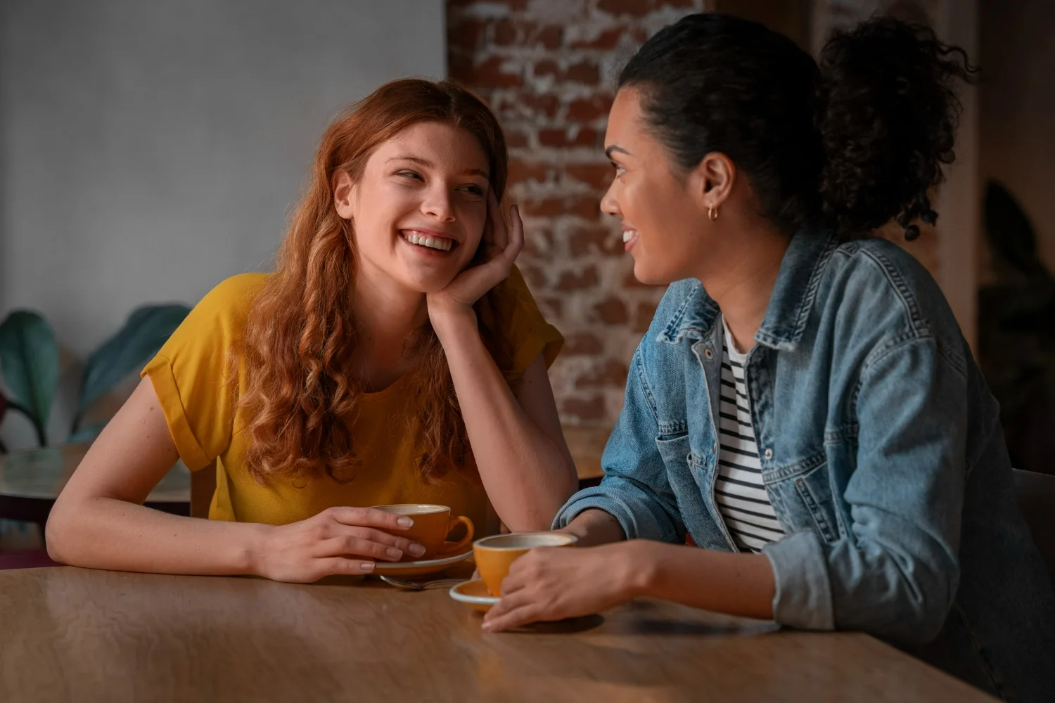 Mulheres sorrindo e conversando, criando uma conexão amigável com café.
