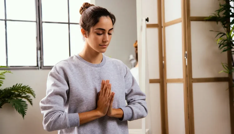 Mulher em posição de meditação, praticando mindfulness em ambiente tranquilo