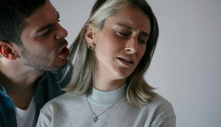 Mulher desconfortável enquanto homem grita próximo ao seu rosto, ilustrando abuso verbal narcisista.