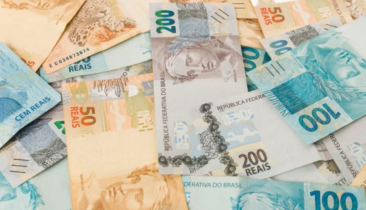 Notas de dinheiro brasileiro, incluindo cédulas de 100, 200, 50 e 10 reais, sobre fundo neutro.