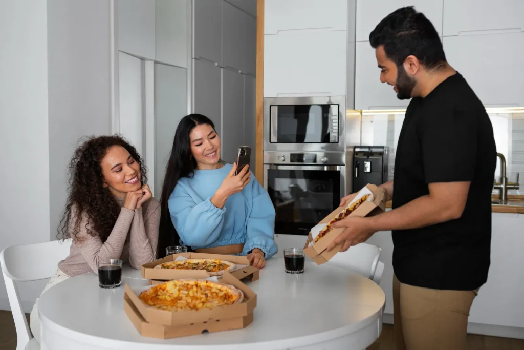 Grupo de amigos felizes recebendo pizza em casa