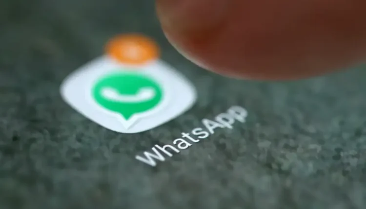 Ícone do WhatsApp sendo pressionado na tela de um celular.