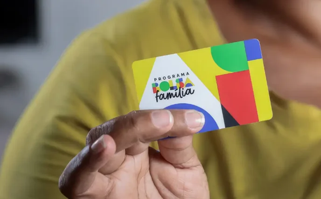 Pessoa segurando o cartão do Programa Bolsa Família, um benefício essencial para a assistência social.