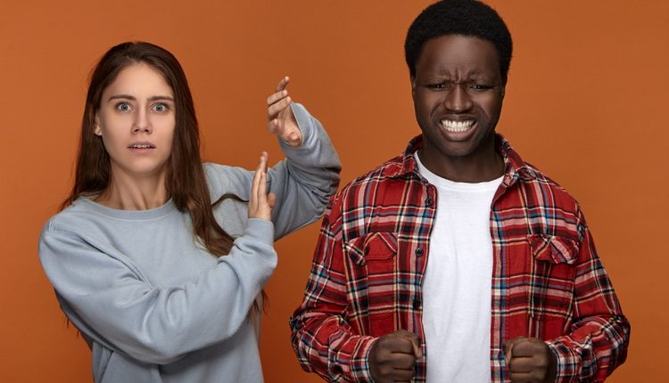 Casal discutindo em um ambiente fechado, simbolizando os sinais de estresse e ansiedade quando há dificuldades em resolver conflitos.