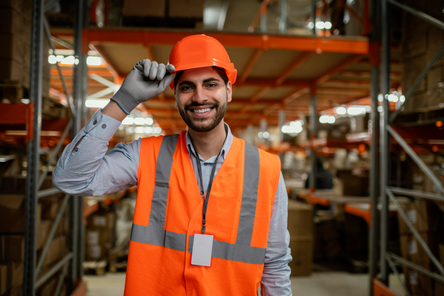 Homem sorridente com uniforme de segurança em ambiente de trabalho.