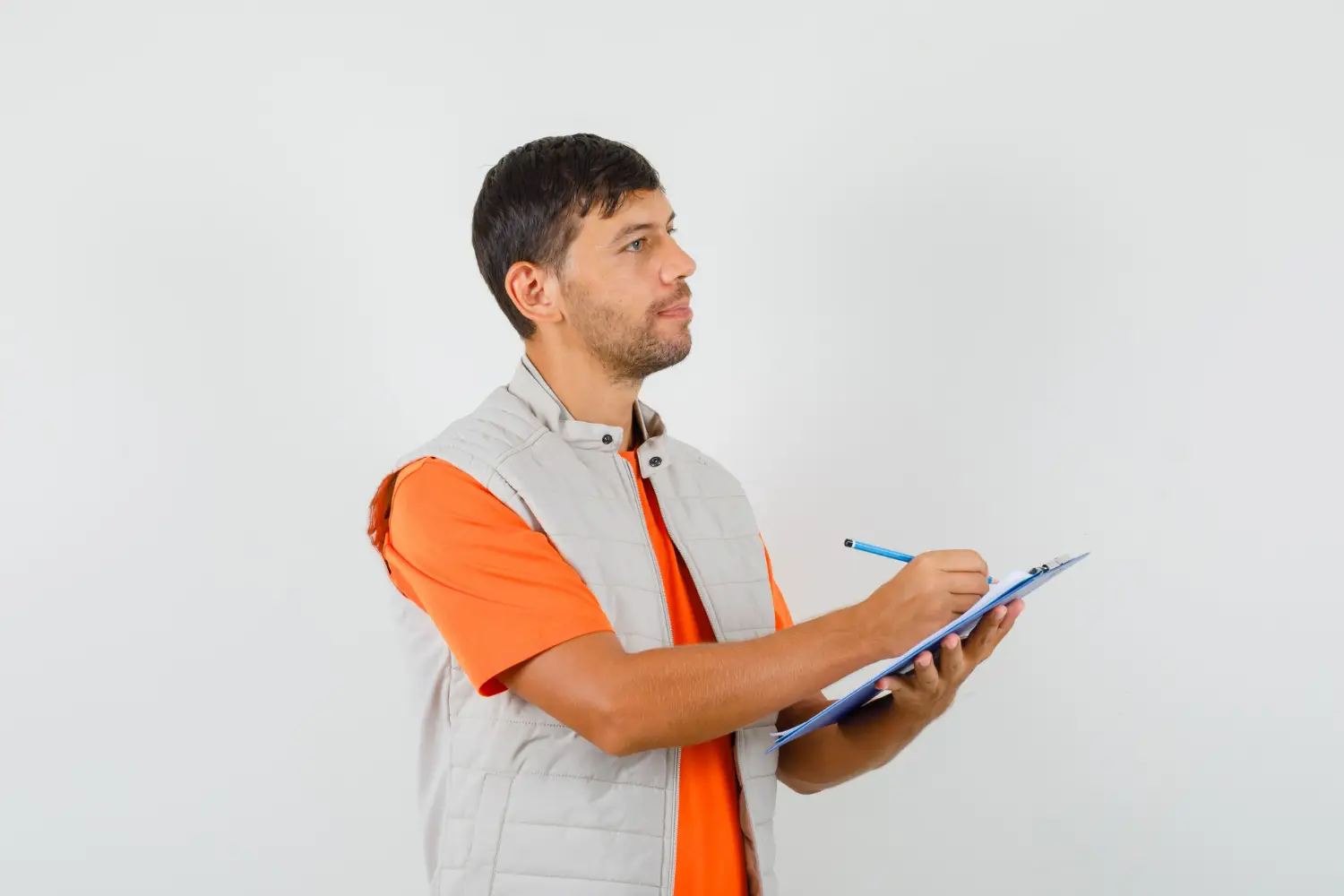 Profissional em uniforme técnico, fazendo anotações enquanto reflete sobre a escolha de um curso técnico.
