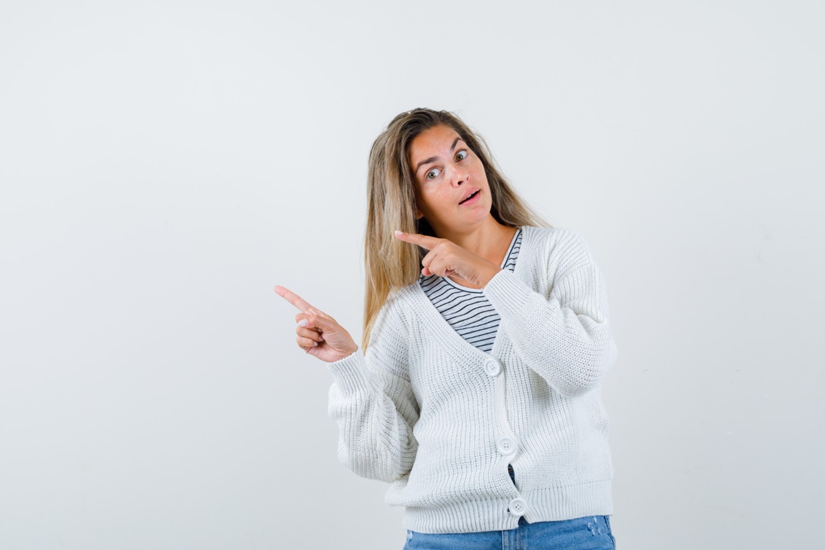 Mulher com blusa branca, apontando para algo
